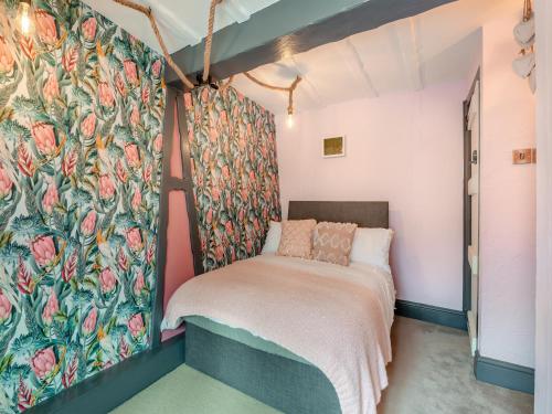 a bedroom with a bed with a floral wallpaper at The Tipsy Bee At 143, in Guisborough