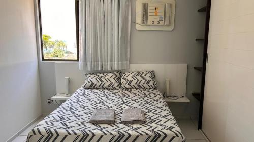 1 dormitorio pequeño con 1 cama con 2 toallas en Lindo Apartamento com piscina à 100m do MAR, en Recife
