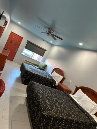 a living room with two beds and a ceiling fan at La Copa Inn Alamo in Alamo