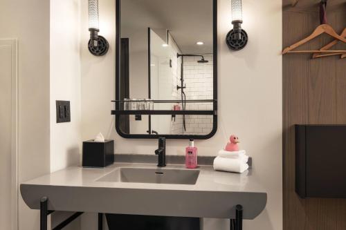 a bathroom with a sink and a mirror at Moxy Louisville Downtown in Louisville