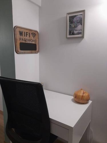 a desk with a chair and a sign on a wall at Calme et simplicité in Chelles