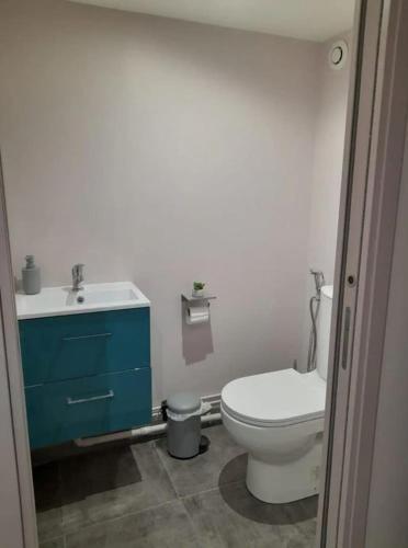 a bathroom with a toilet and a sink at Calme et simplicité in Chelles