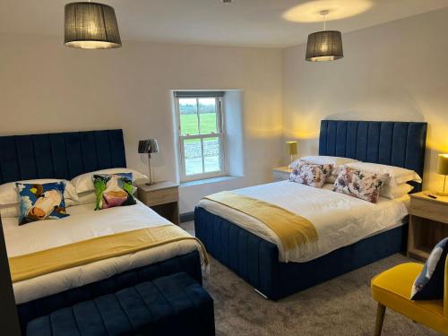 1 dormitorio con 2 camas y ventana en The Burren Inn en Tubber