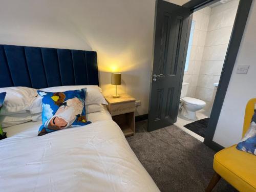 a bedroom with a bed with a blue headboard and a toilet at The Burren Inn in Tubber
