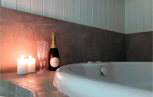 - une bouteille de champagne et un verre de vin à côté d'une baignoire dans l'établissement Stunning Home In Nykbing Sj With Sauna, Wifi And Indoor Swimming Pool, à Lumsås