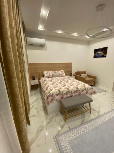 a bedroom with a bed and a chair in it at Apartman Cristal LUX in Trebinje