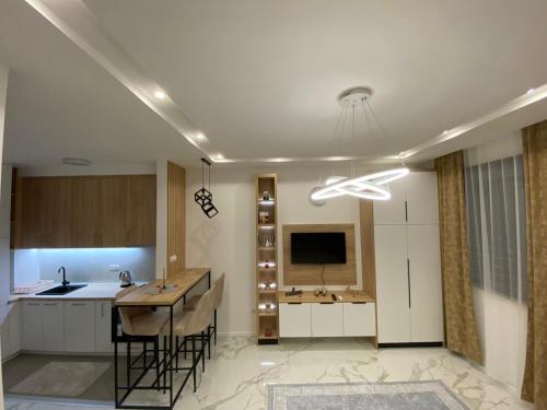 a kitchen with a table and a television in it at Apartman Cristal LUX in Trebinje