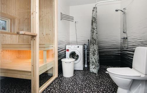een badkamer met een toilet, een douche en een wasmachine bij Awesome Home In Holmsj With Kitchen in Holmsjö
