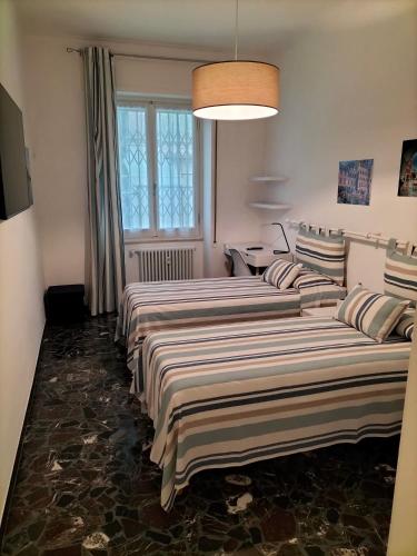 a row of beds in a room with a window at BUENOS AYRES 45 in Chiavari