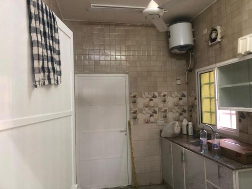 a kitchen with a white door and a sink at Haret Nizwa hostel in Nizwa