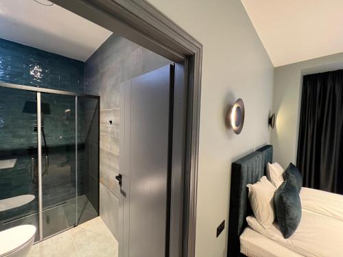 a bathroom with a shower and a bed and a sink at Comfort Hostel Klaipeda in Klaipėda