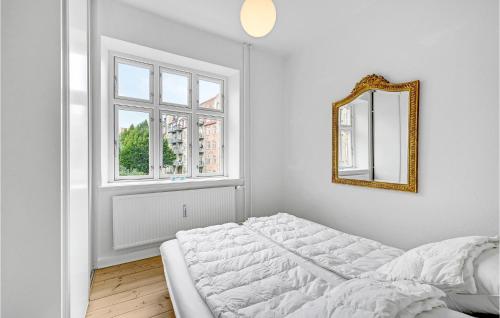 a white bedroom with a bed and a mirror at Amazing Apartment In Aarhus C With 1 Bedrooms And Wifi in Aarhus