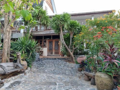 a courtyard of a house with trees and plants at Sawasdee Sichang Resort in Ban Tha Thewawong