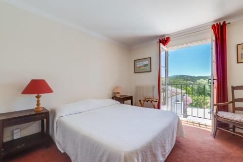a bedroom with a bed and a balcony at Hôtel La Boulangerie in Grimaud