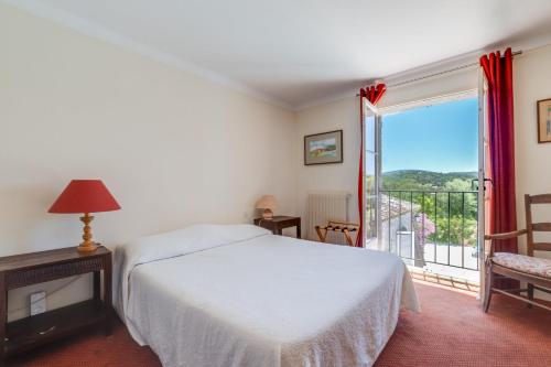 um quarto com uma cama e uma varanda em Hôtel La Boulangerie em Grimaud