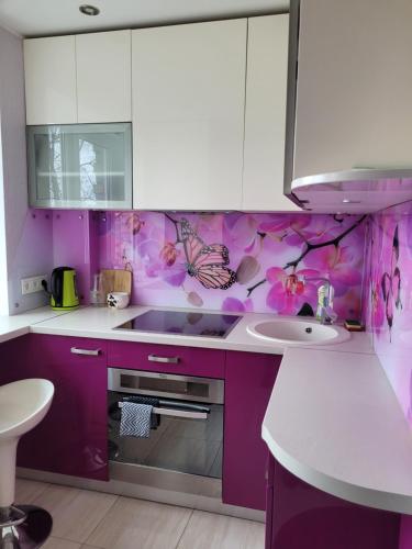 a purple kitchen with a sink and a counter top at City apartment in Jelgava