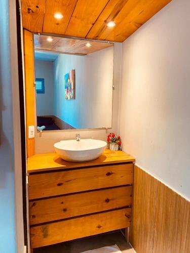 LagoinhaKitePoint في بارايبابا: حمام مع حوض ومرآة على خزانة الملابس