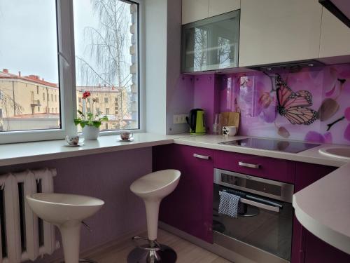 a purple kitchen with a sink and a window at City apartament in Jelgava