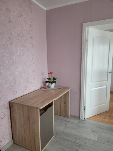 a room with a wooden table with a plant on it at City apartament in Jelgava