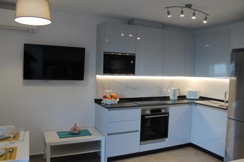 a kitchen with white cabinets and a stove top oven at Brand New Studio with Sea View in Gibraltar