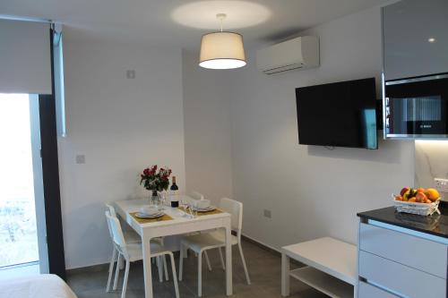 a small kitchen with a table and chairs in a room at Brand New Studio with Sea View in Gibraltar