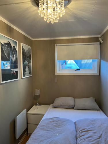 um quarto com uma cama, uma janela e um lustre em Sentralt i Fredrikstad gratis parkering em Fredrikstad