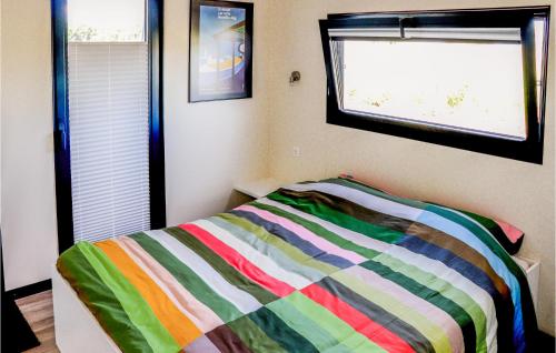 a bedroom with a bed with a colorful striped blanket at Gorgeous Ship In Nieuwpoort With House Sea View in Nieuwpoort
