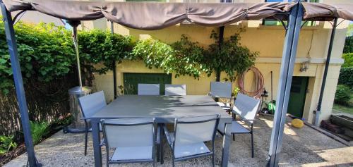 une table et des chaises sous un parasol dans l'établissement Maison lumineuse dans un cadre verdoyant, à Saint-Prix