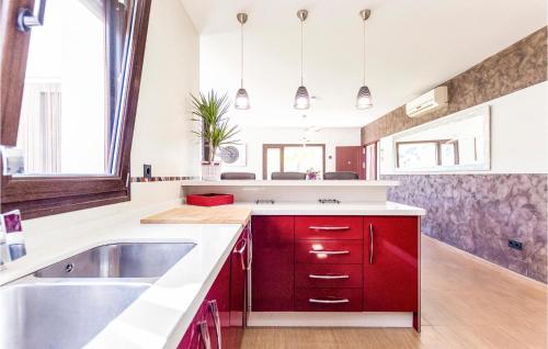 una cocina con armarios rojos y fregadero en Beautiful Home In Malaga With Kitchen, en Málaga