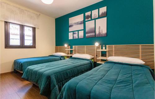 2 camas en una habitación con paredes azules en Beautiful Home In Malaga With Kitchen, en Málaga