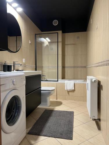 a bathroom with a washing machine and a toilet at Apartament Stara Motława in Gdańsk