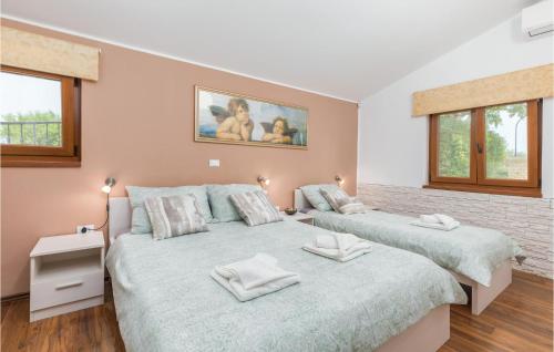 two beds in a bedroom with two windows at Lovely Home In Sv,kirin With Kitchen in Juršići