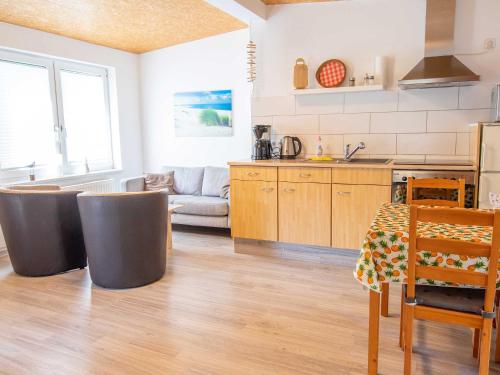Bungalow Neues Atelier في لوبمين: مطبخ وغرفة معيشة مع طاولة وكراسي