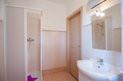 une salle de bain blanche avec un lavabo et une douche dans l'établissement B&B Duino Stella Maris, à Duino