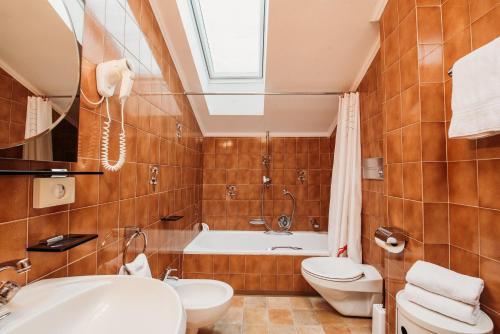 uma casa de banho com uma banheira, um WC e um lavatório. em Gästehaus Marianne Terenten em Terento