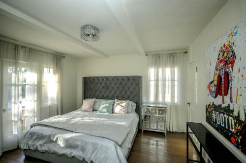 a bedroom with a large bed and some windows at Gorgeous Renovated 3BD 2BA near West Hollywood and Beverly Hills in Los Angeles