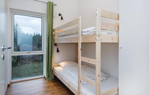 HolmsjöにあるBeautiful Home In Holmsj With Wifiの二段ベッド2台と窓が備わる客室です。