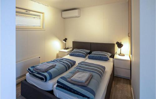 アールスメールにある2 Bedroom Cozy Ship In Aalsmeerのベッドルーム1室(青い枕付きのベッド2台付)
