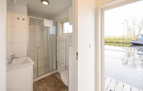 baño con lavabo y aseo y ventana en 2 Bedroom Cozy Ship In Aalsmeer, en Aalsmeer