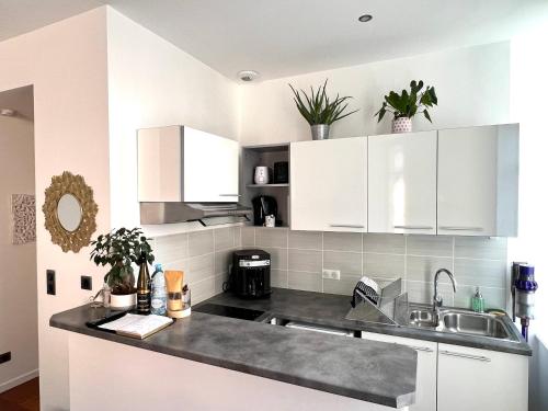 a kitchen with white cabinets and a sink at HYPER CENTRE - Colmar Cathédrale - PARKING Gratuit in Colmar