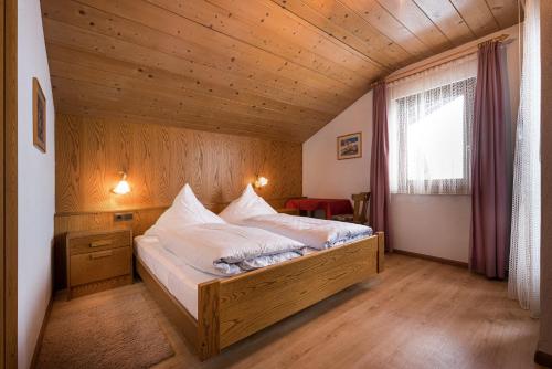 a bedroom with a bed in a room with wooden walls at Gästehaus Marianne Terenten in Terento