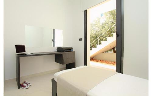 1 dormitorio con cama con espejo y escritorio en Lovely Home In Karbuni With Kitchen, en Prizba