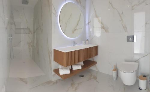 a bathroom with a sink and a mirror and a toilet at Villa Algarve in Alcantarilha