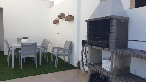 a patio with a table and chairs and a fireplace at Villa Algarve in Alcantarilha