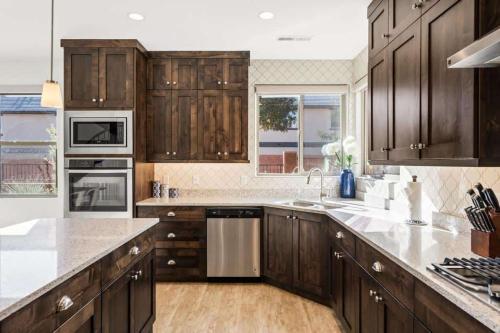 eine Küche mit Holzschränken und einem großen Fenster in der Unterkunft Desert Solitaire #101 townhouse in Santa Clara