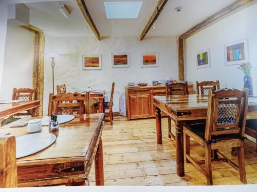 ein Esszimmer mit Holztischen und -stühlen in der Unterkunft The Boat House Bed and Breakfast in Laugharne