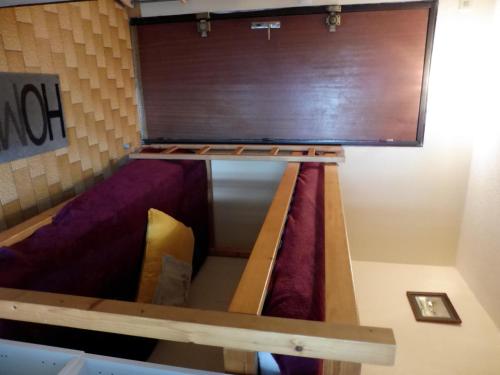 Ce lit superposé se trouve dans un dortoir doté d'un mobilier violet. dans l'établissement GENOIS Joli studio cabine Mt St Martin proche port Cap d'Agde, au Cap d'Agde