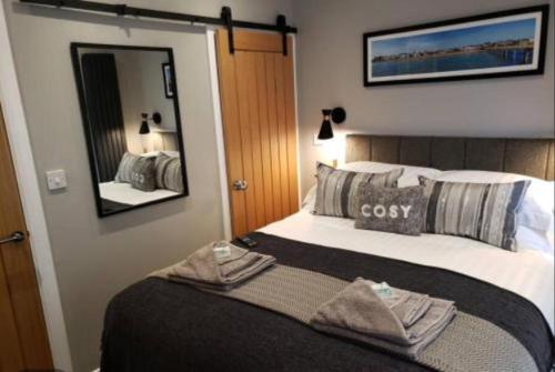 1 dormitorio con 1 cama grande y espejo en The Courtyard - Cosy, secluded with luxury suite en Walmer