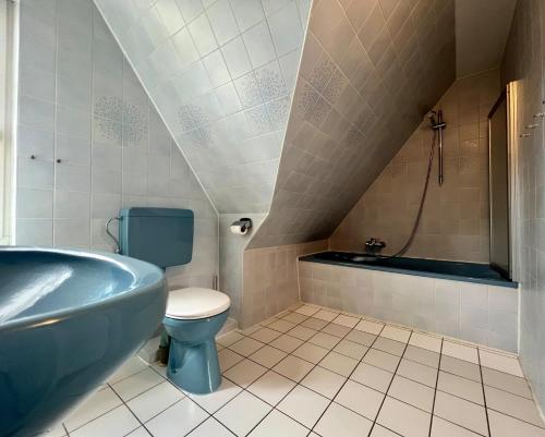 a bathroom with a blue tub and a toilet at Haus Friesenfeuer in Nieblum