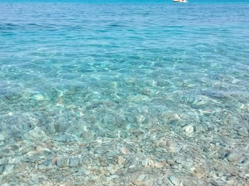 a group of rocks in the water on a beach at Casa Morello in Zambrone